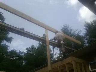Carpenter setting a ridge beam over a new addition frame — Ice Dam Removal by Roofing Brothers in Redkey