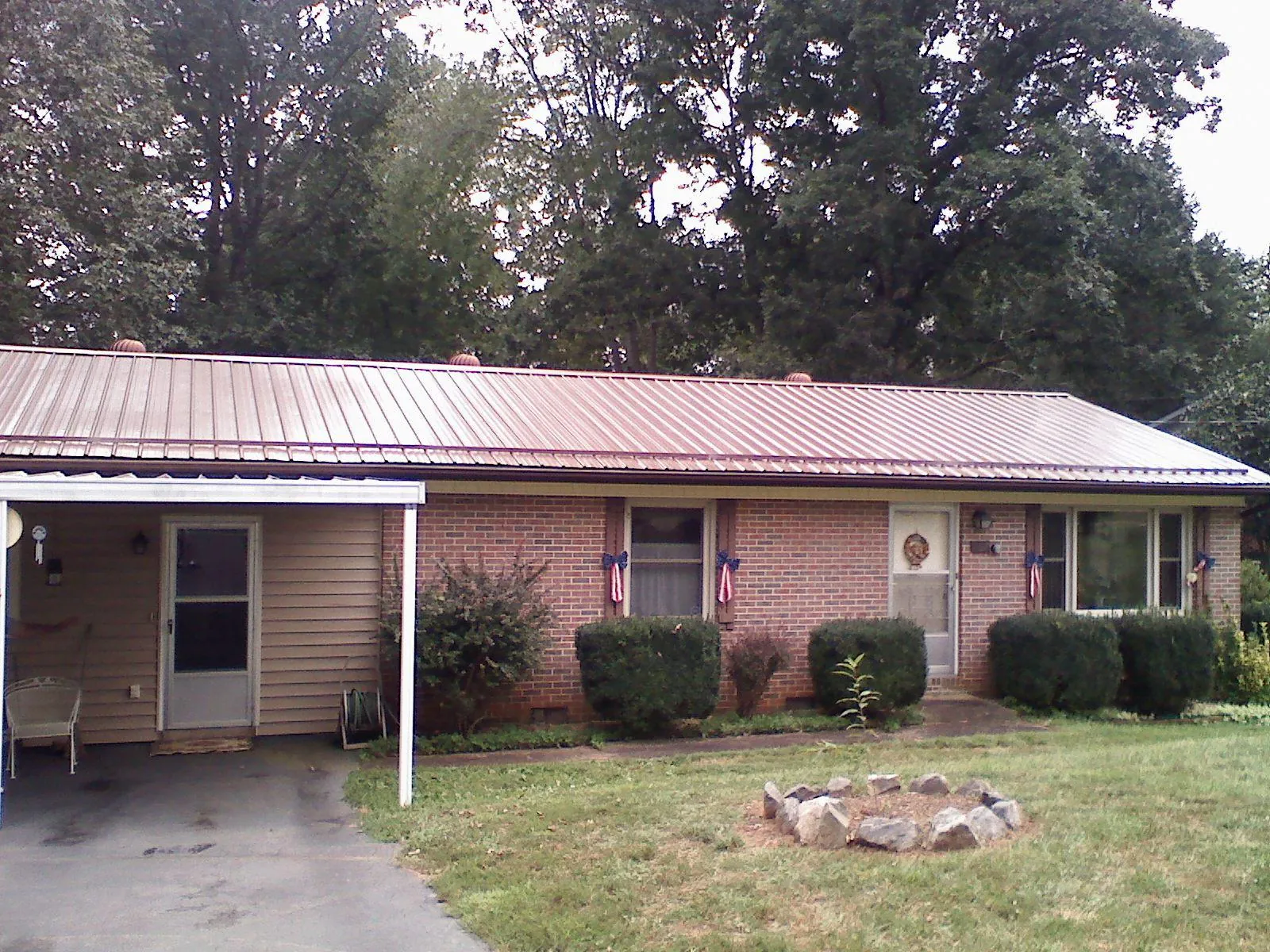 Bronze metal roof and carport on a brick ranch home — Roof Repair work by our crew in Redkey