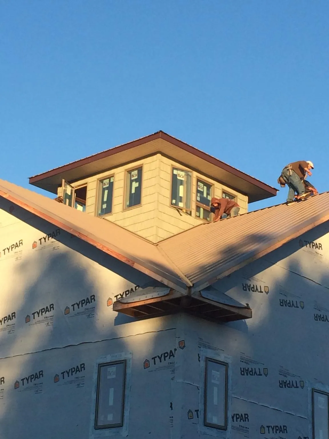 Roofers working around a rooftop cupola on a new metal roof at sunset — Roof Waterproofing in Redkey by Roofing Brothers
